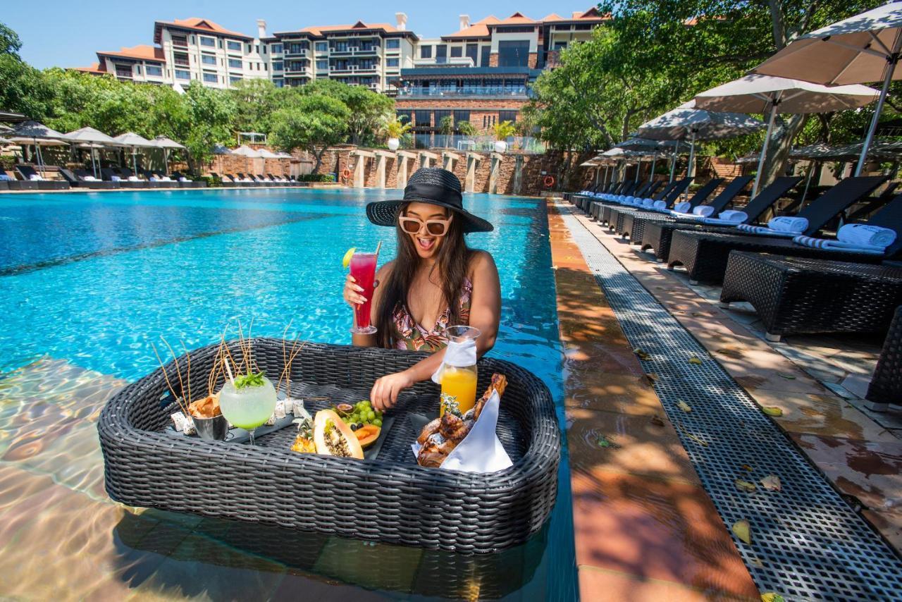 Hotel The Capital Zimbali Ballito Exteriér fotografie A woman at a poolside lounge